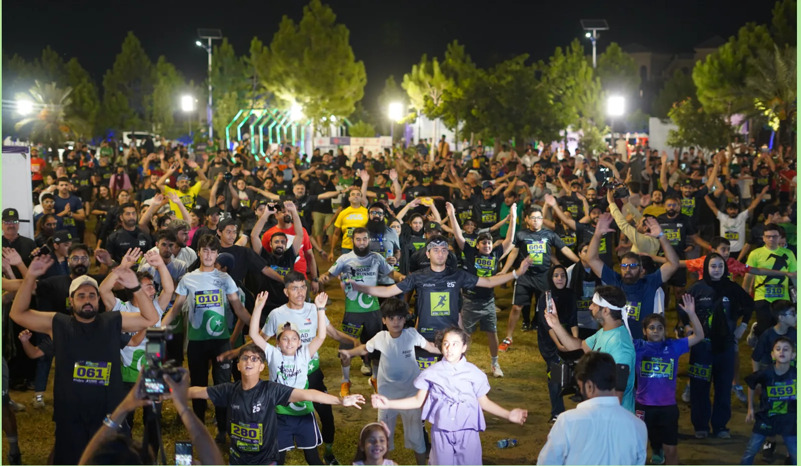 A dense crowd of runners under floodlights before the start