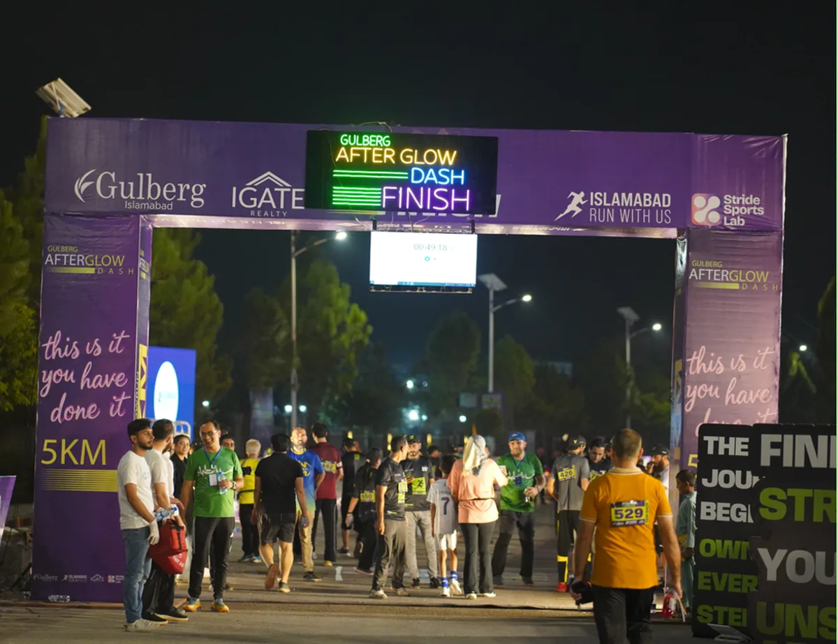 The lit finish arch with the partner logos and encouragement signage along the barriers