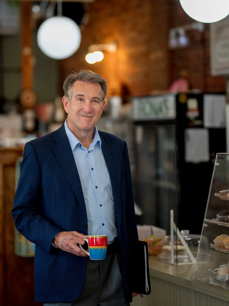 Don Scott photographed in a cafe, in a navy blazer